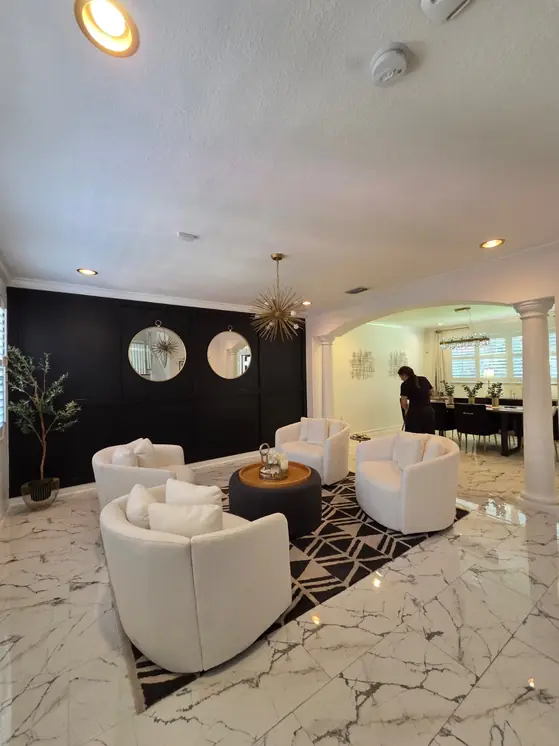 An AYA Nova team member at work in a living room with marble floors