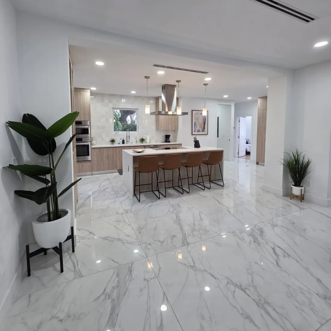 Open kitchen and polished marble floors in a home cleaned by AYA Nova